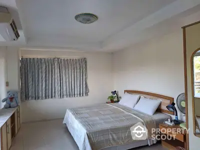 Spacious bedroom with ample natural light, featuring a large bed, air conditioning, and a serene view through the window, perfect for relaxation.