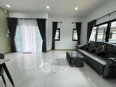 Spacious modern living room with elegant gray sofa and large windows