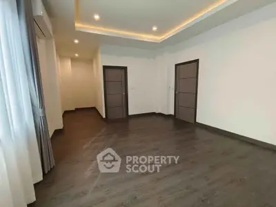 Spacious modern room with elegant wood flooring and ambient lighting