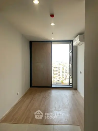 Spacious unfurnished room with large window and city view