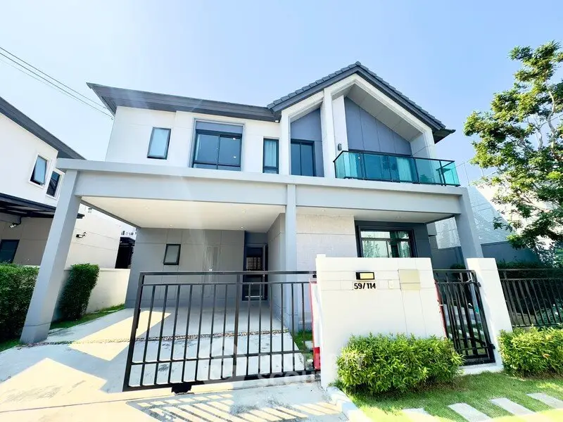 Modern two-story house with sleek design and spacious driveway in a serene neighborhood.