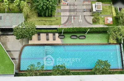 Stunning aerial view of a luxurious swimming pool surrounded by lush greenery in a modern residential complex.