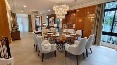 Luxurious dining room with elegant chandelier and modern decor in a spacious open layout.