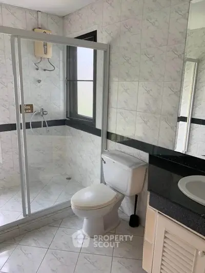 Modern bathroom with glass shower enclosure and sleek fixtures