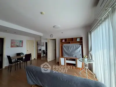 Spacious living room with modern decor and natural light, perfect for relaxation and entertainment.