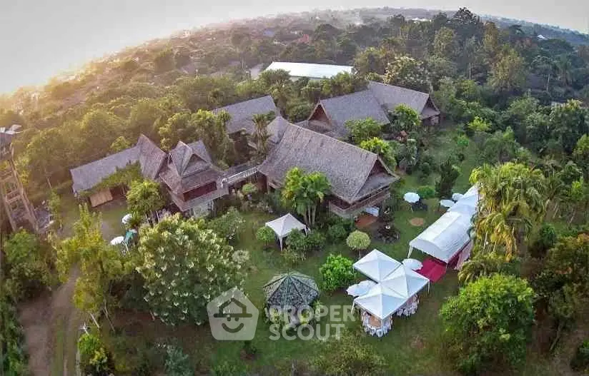 Stunning aerial view of a tropical resort with lush gardens and traditional architecture, perfect for a serene getaway.