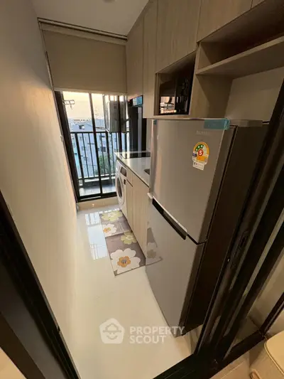 Compact kitchen with modern appliances and balcony view