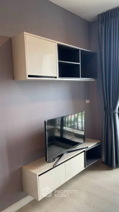 Modern living room with sleek TV stand and wall-mounted storage unit