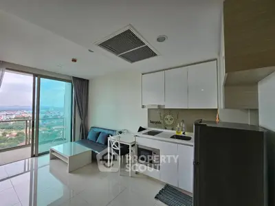 Modern apartment with open kitchen and stunning city view from balcony.