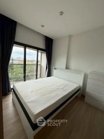 Spacious bedroom with large window and scenic view, featuring modern furnishings and ample natural light.