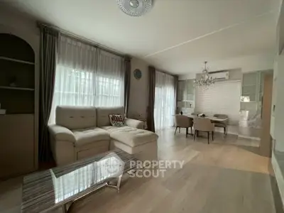 Elegant living room with plush sofa, chic dining area, and large windows for natural light.