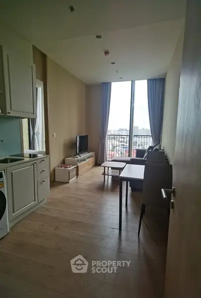Modern living room with balcony view, featuring sleek furniture and natural light.