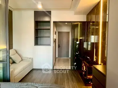 Modern living room with sleek design and ambient lighting, featuring a cozy sofa and built-in shelving.