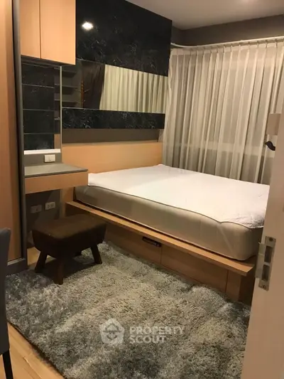 Cozy bedroom with modern decor and plush rug in a stylish apartment.