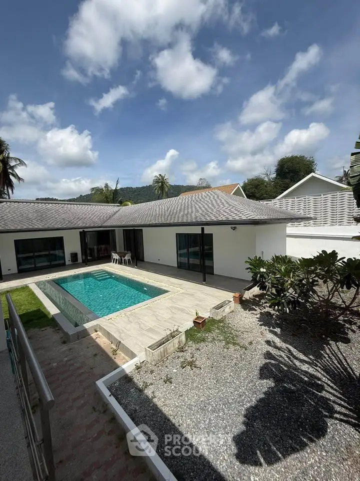 Luxurious villa with private pool and spacious outdoor area under a clear blue sky.