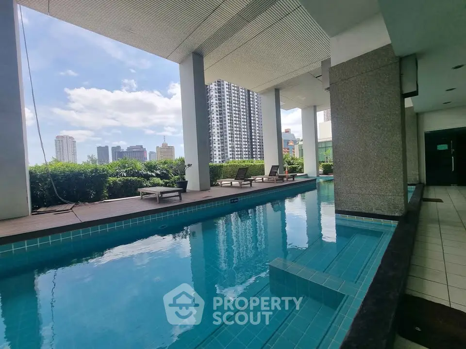 Luxurious rooftop pool with stunning city skyline views in modern high-rise building.