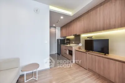 Modern open-layout kitchen with sleek wooden cabinetry and integrated appliances in a stylish apartment.