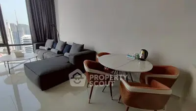 Modern living room with city view, stylish furniture, and dining area in a high-rise apartment.