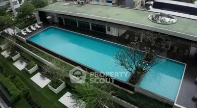Luxurious rooftop pool with lush greenery and modern design in urban setting.
