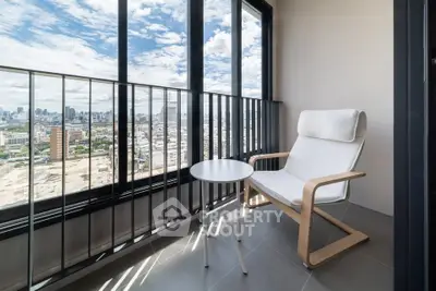 Modern balcony with city view, featuring a cozy chair and table, perfect for relaxation.