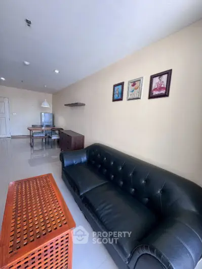Spacious living room with elegant black leather sofa and modern decor