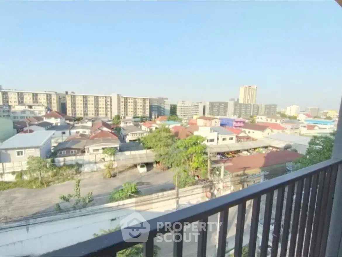 Stunning urban view from a high-rise balcony overlooking cityscape and residential area.