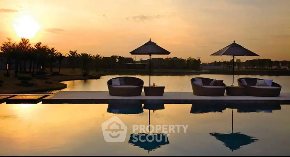 Luxurious poolside view at sunset with elegant seating and serene water reflections.
