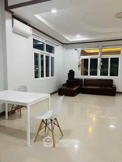 Spacious modern living room with sleek furniture and large windows for natural light.