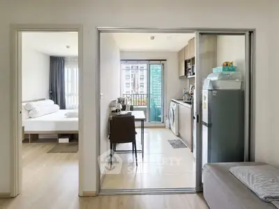 Modern apartment interior with open kitchen and cozy bedroom, featuring sleek design and natural light.