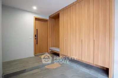 Modern entryway with sleek wooden cabinetry and stylish flooring