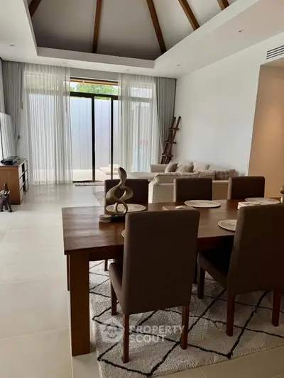 Elegant living room with dining area, modern decor, and large windows for natural light.