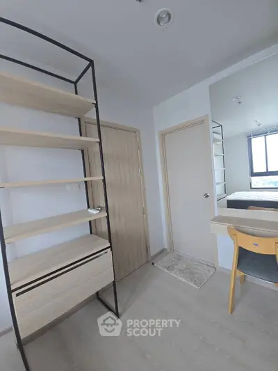 Modern study room with wooden shelves and desk, bright window view.