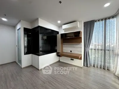 Modern living room with sleek design, large window, and built-in shelving unit.