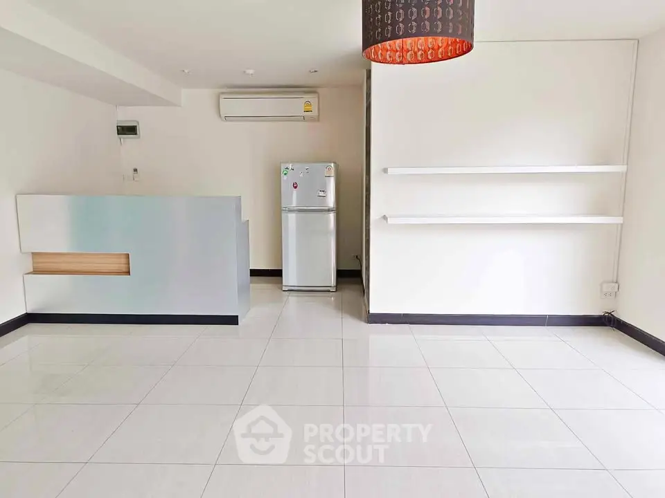 Spacious modern living room with sleek tile flooring and minimalist design.