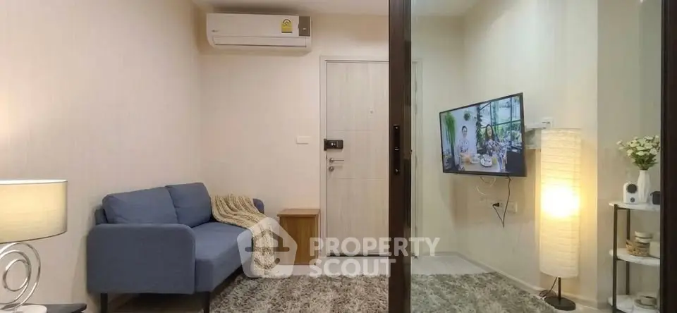 Cozy living room with modern decor and wall-mounted TV in a stylish apartment.