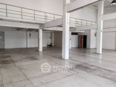 Spacious industrial warehouse with high ceilings and mezzanine level, ideal for storage or manufacturing.