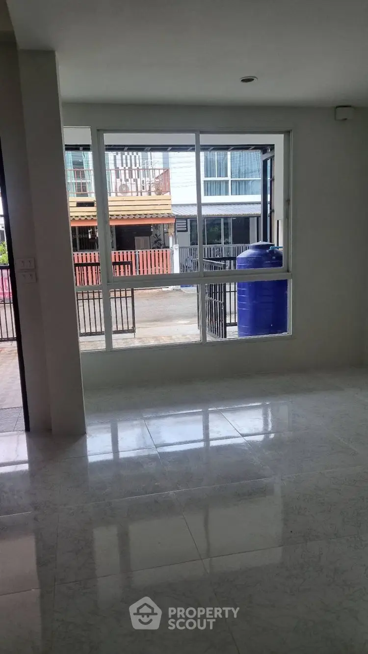 Spacious interior with large window offering street view, ideal for natural light.