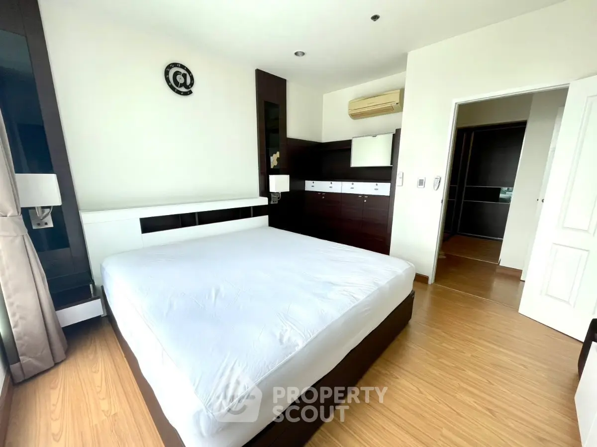 Spacious modern bedroom with wooden flooring and stylish decor