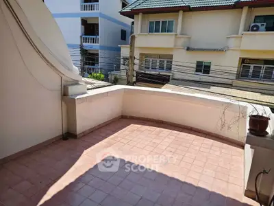 Spacious balcony with tiled flooring and street view in a residential area.