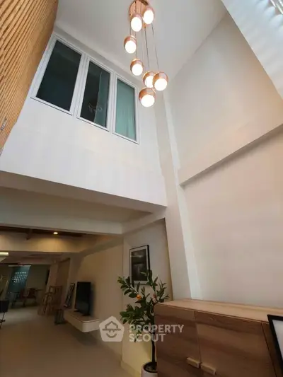 Spacious modern living room with high ceiling and elegant lighting