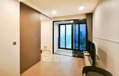 Modern living room with balcony and city view, featuring sleek design and ample natural light.