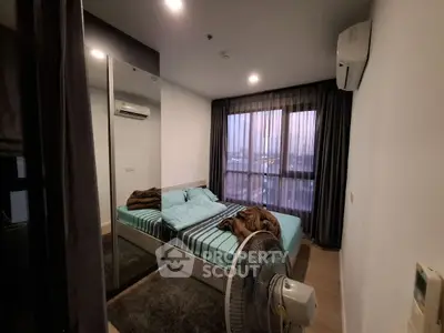 Cozy bedroom with large window and modern decor, featuring air conditioning and a comfortable bed.
