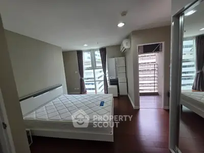 Spacious bedroom with modern design and large windows offering city views.