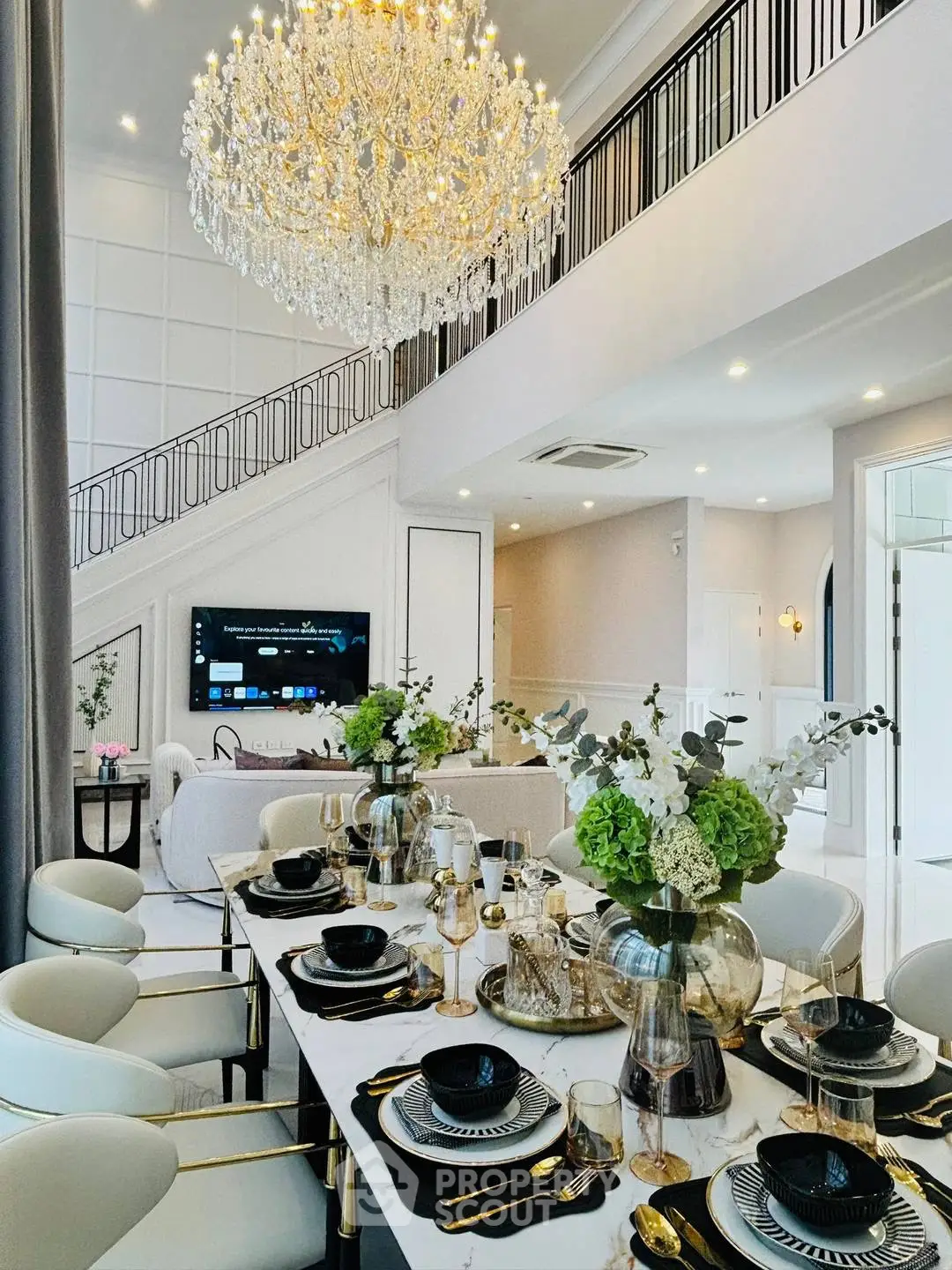 Luxurious dining area with elegant chandelier and modern decor in a spacious open-plan living room.