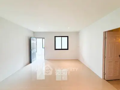 Spacious empty room with glossy tiled floor and natural light