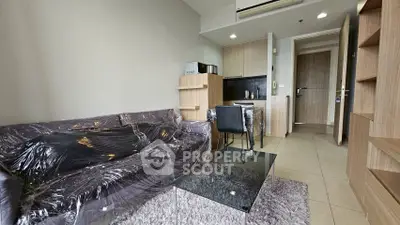 Modern living room with cozy furniture and compact kitchen area, ideal for urban living.