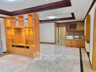 Spacious living room with elegant wooden cabinetry and marble flooring