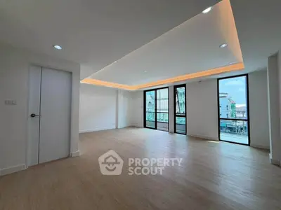 Spacious modern living room with large windows and elegant lighting