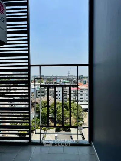 Modern apartment balcony with city view and sleek railing design.