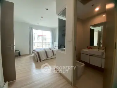 Modern bedroom with ensuite bathroom and large window for natural light